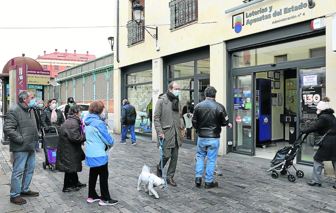 Varias personas guardan cola para acceder a la administración de la Plaza Mayor. 