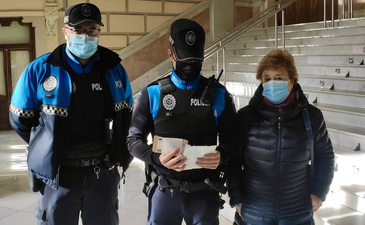 Un agente examina el dinero y el recibo entregado por la mujer. 