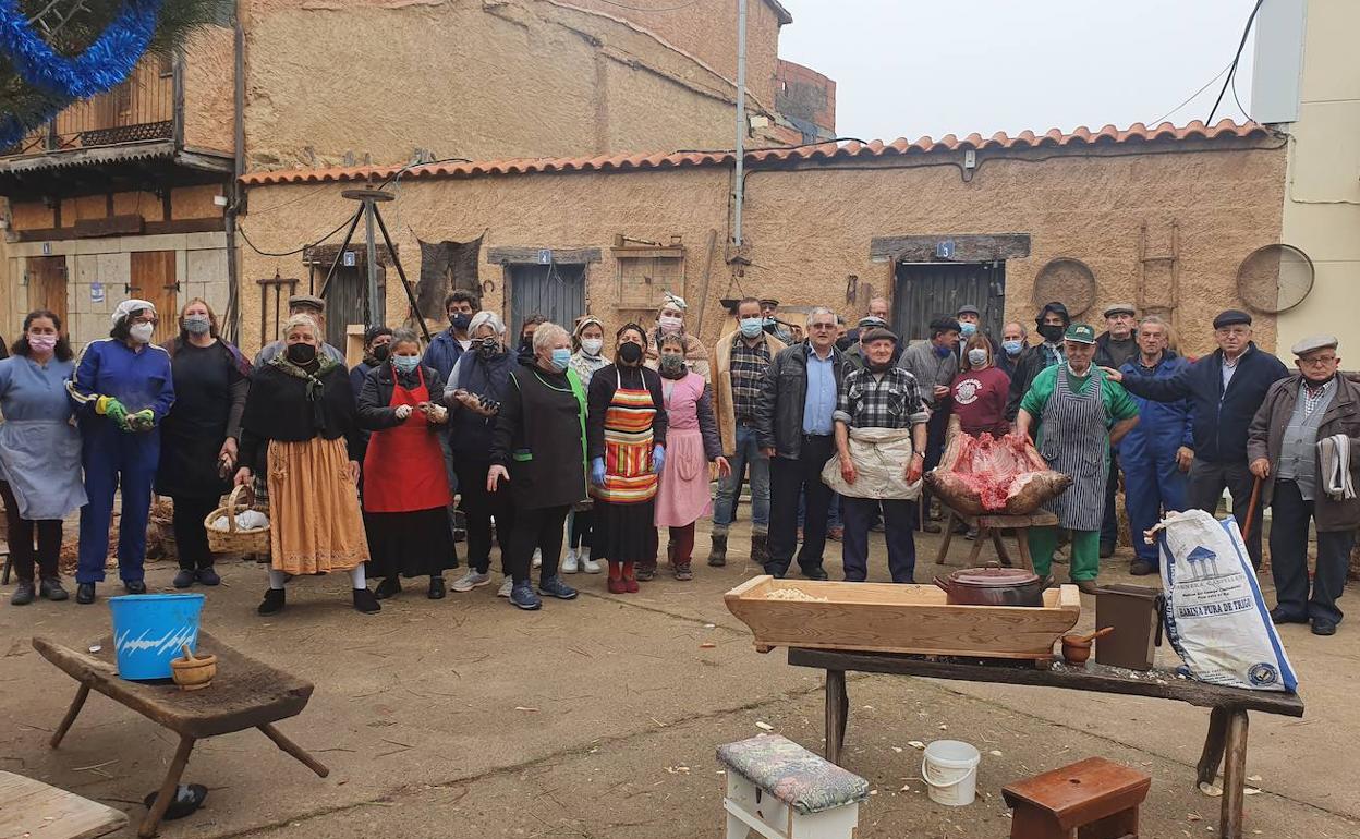 Hombres y mujeres que participaron en el desarrollo de la matanza tradicional, junto al cerdo.