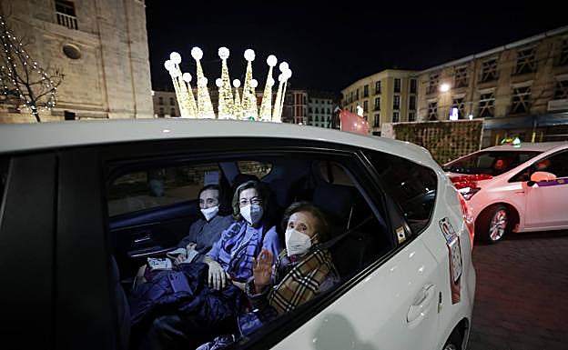 Tres mujeres pasan por la plaza Portugalete montadas en un taxi para ver las luces de Navidad. 