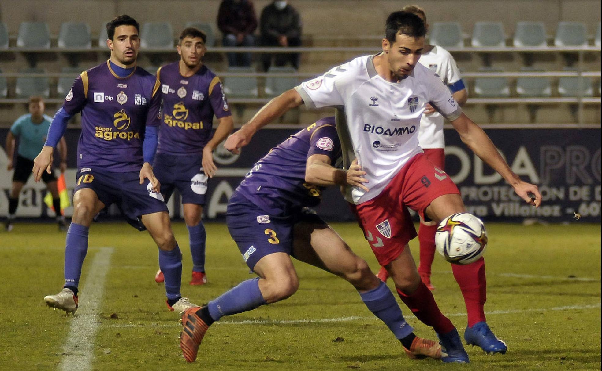 Dani Gómez trata de zafarse del marcaje de los rivales del Cristo Atlético de Palencia en el partido de este domingo. 