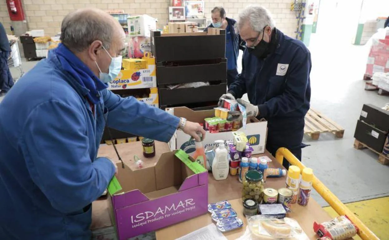 Voluntarios del Banco de Alimentos preparan los lotes de productos no perecederos para repartirlos entre las familias más necesitadas. 