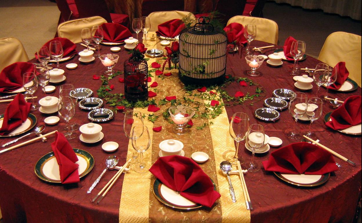 Una mesa de un restaurante, preparada para acoger una cena navideña. 