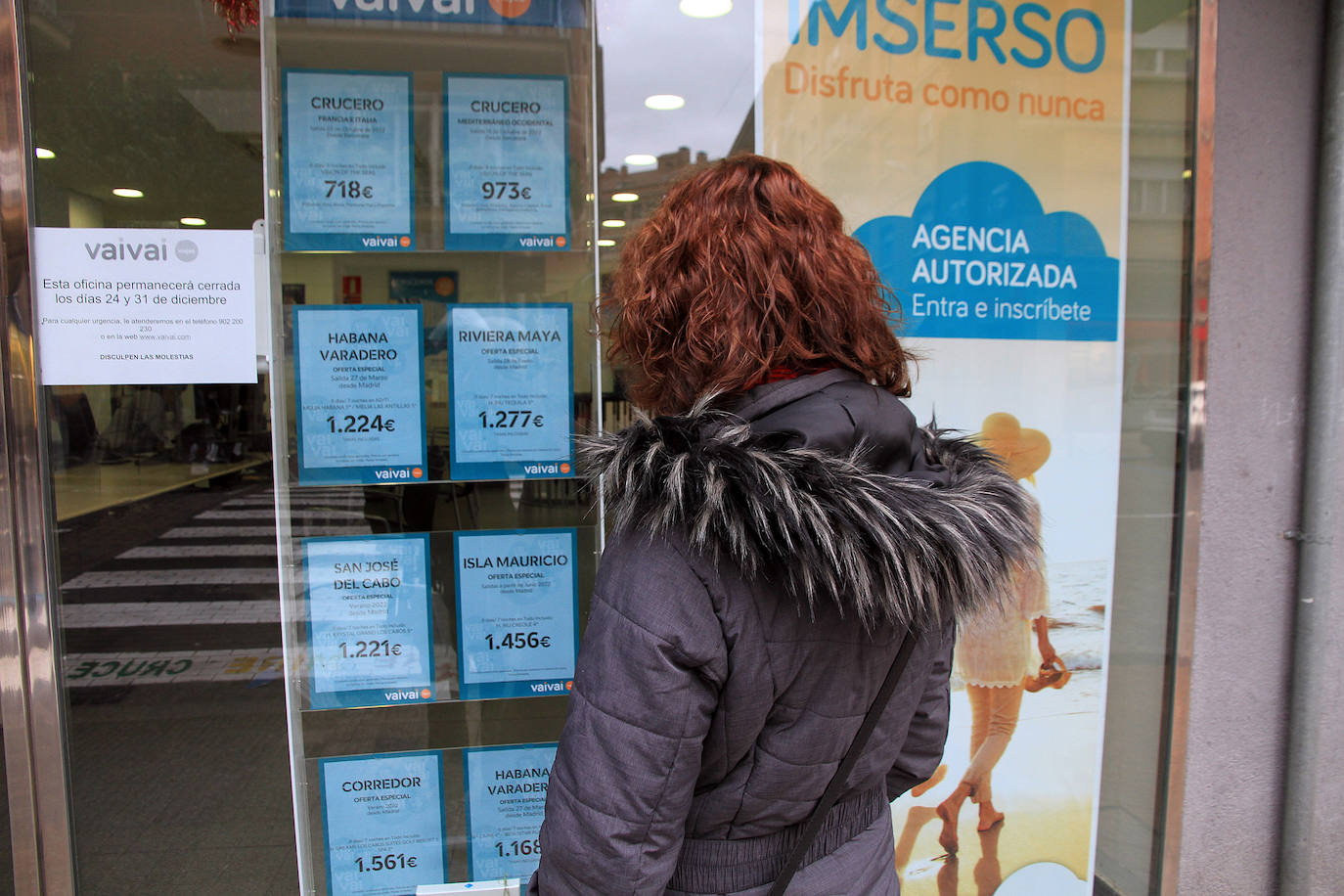 Una mujer mira en el escaparate las ofertas de una agencia de viajes de Segovia.