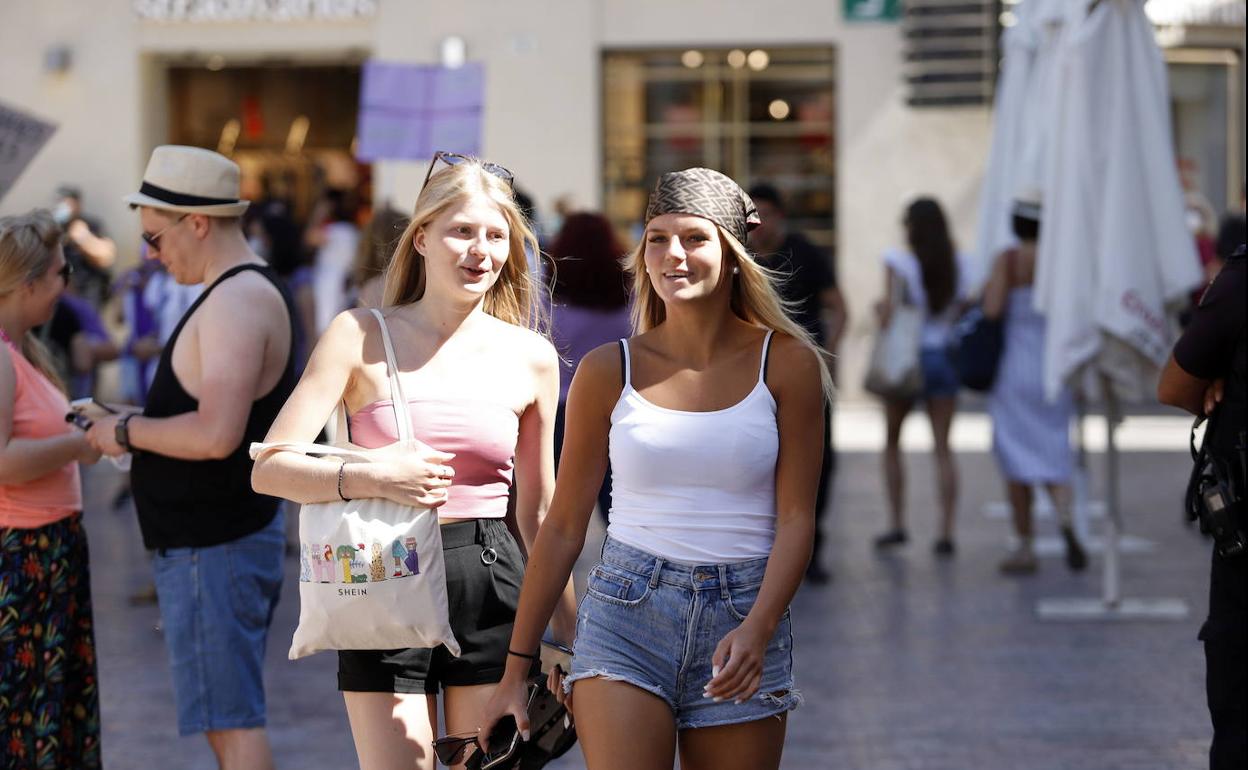 Dos jóvenes sin mascarilla pasean en Málaga.