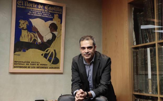El profesor Jesús Ángel Redondo posa en la sede de El Norte de Castilla ante un cartel del ilustrador Penagos, de mediados del siglo XX, sobre el peso de la información agraria en el diario decano de la prensa en España