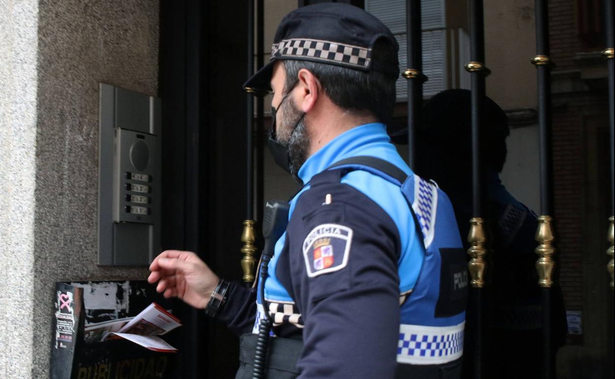 Un agente de la Policía Local llama al portero automático de un domicilio.