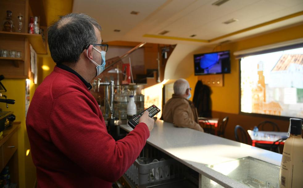 El dueño del bar La Torre, Óscar Curero, cambia de canal la televisión en su negocio. 