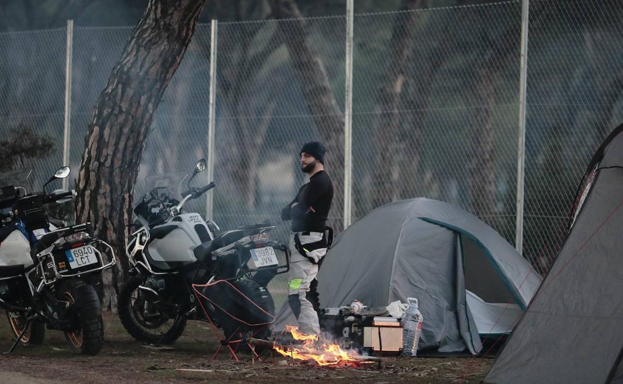 Un motero se calienta junto ak fuego en Pingüinos este jueves. 