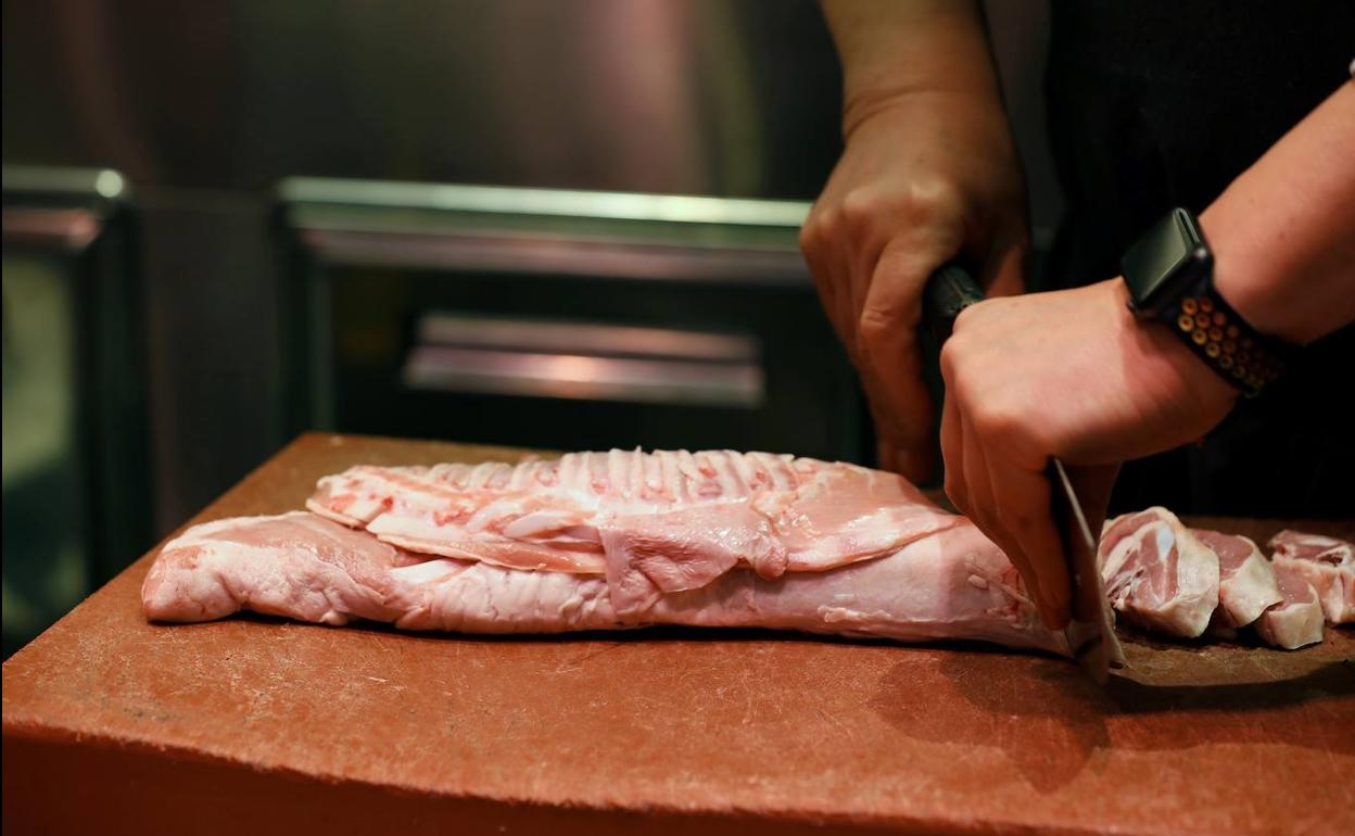 Un dependiente prepara chuletas en el mercado de Chamartín de Madrid. 