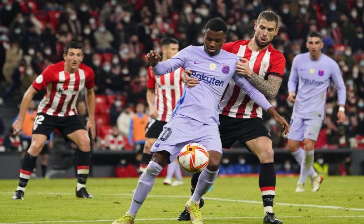 Ansu Fati pelea por un balón con Iñigo Martínez. 