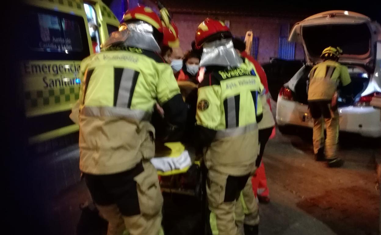 Los bomberos, con el joven herido ayer, ya en la camilla.