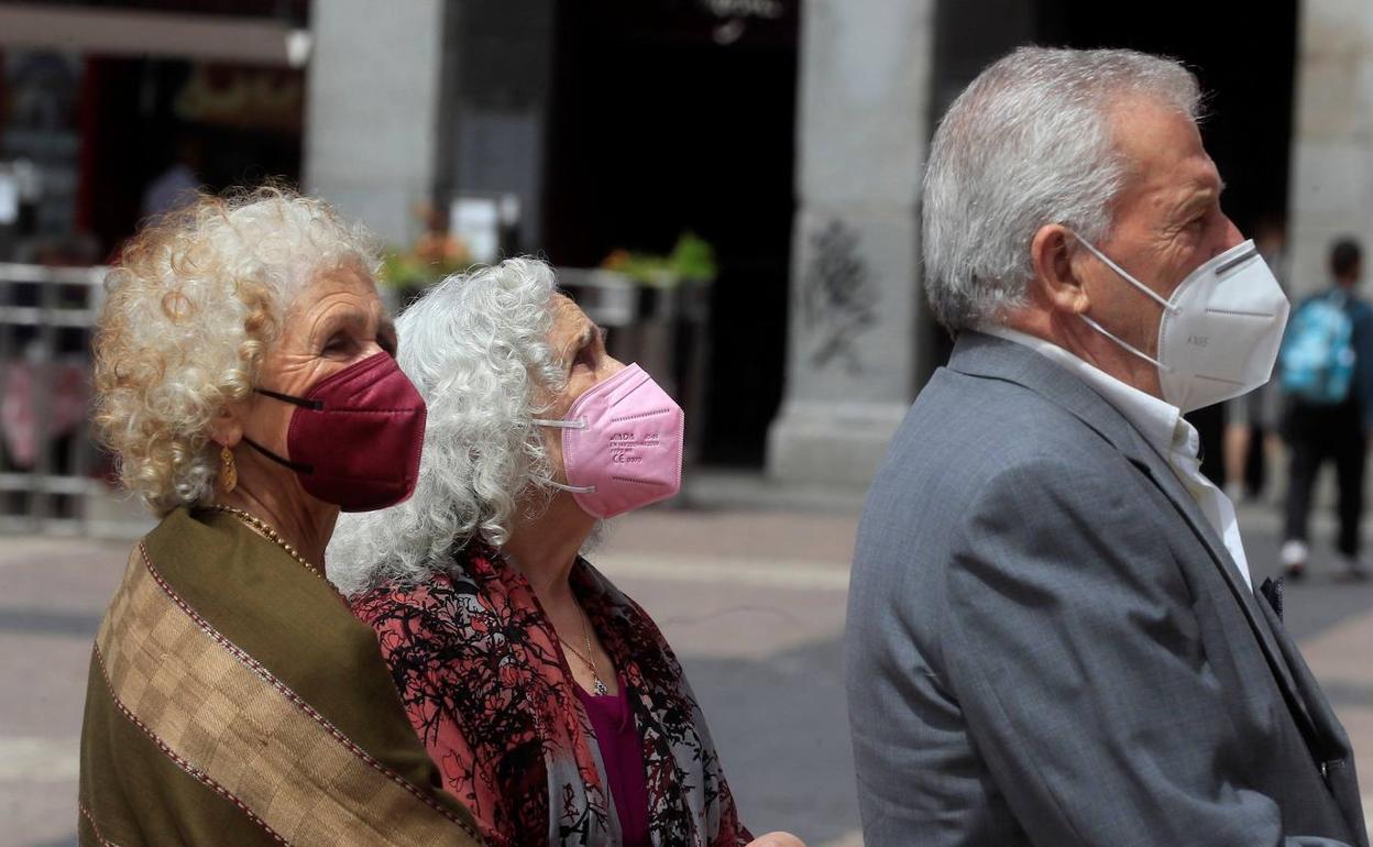 Tres personas pasean por Madrid con mascarilla en junio de 2021.