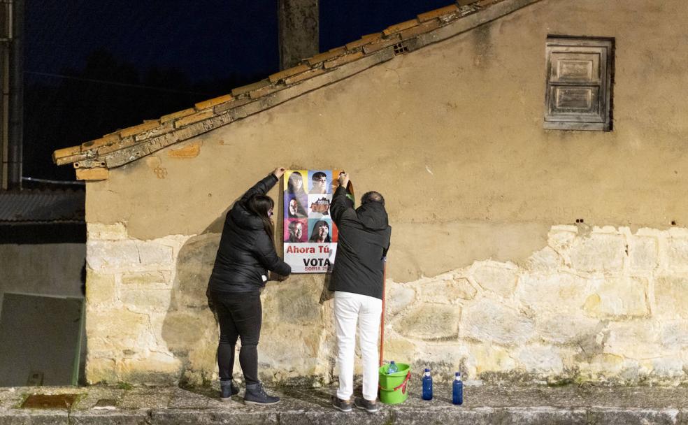 Dos asociados de Soria ¡YA! colocan el cartel electoral en uno de los edificios deshabitados de Cubilla