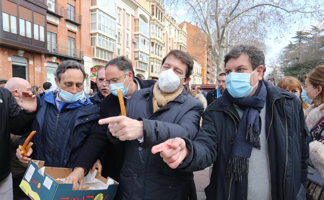 Mañueco y Carriedo degustan unos churros, junto a otros dirigentes y cargos del PP. 