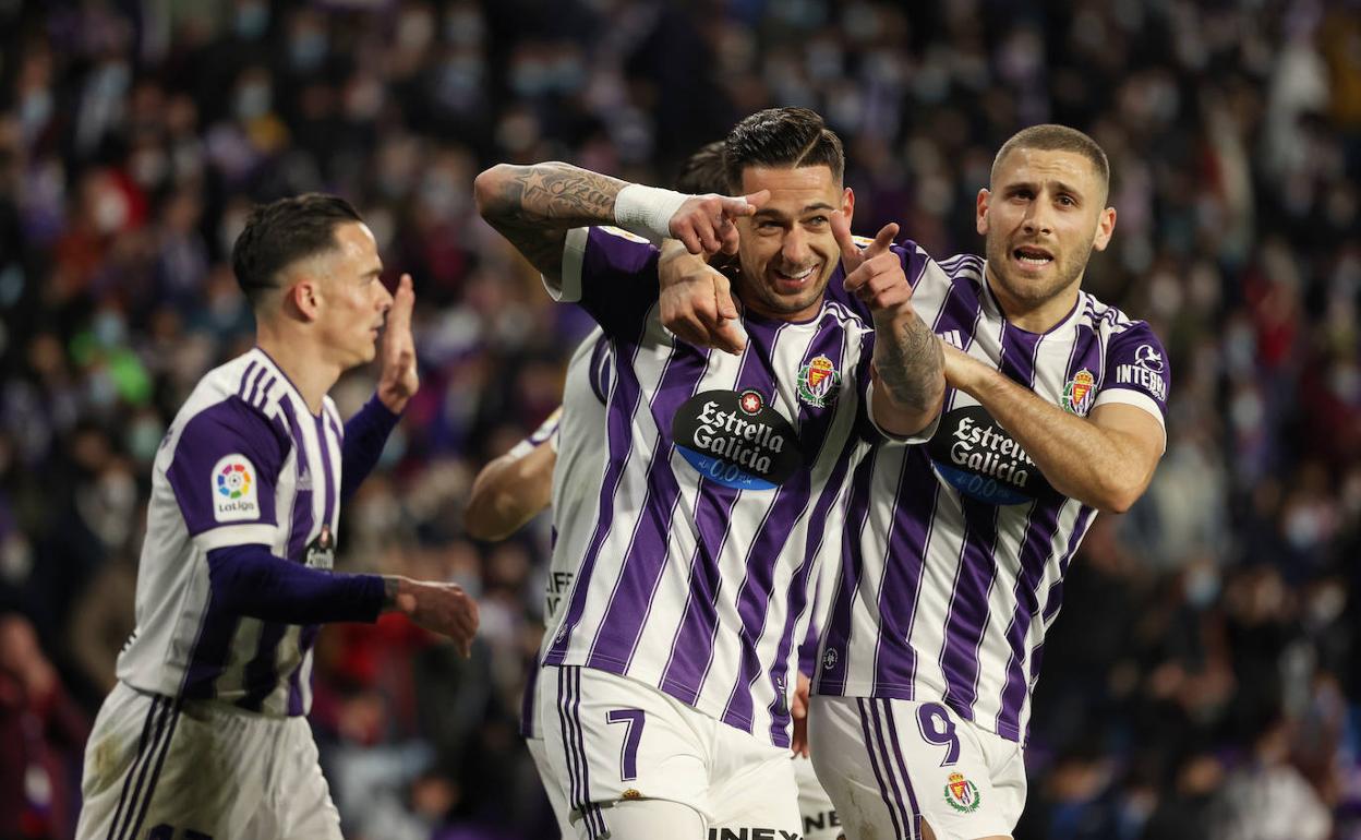 Sergio León, abrazado por Weissman, apunta a la grada en su celebración. 