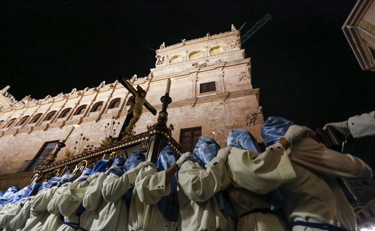 Los hermanos de la Cofradía de la Veracruz portan al Cristo de los Doctrinos junto al Palacio de Monterrey de la capital salmantina. 