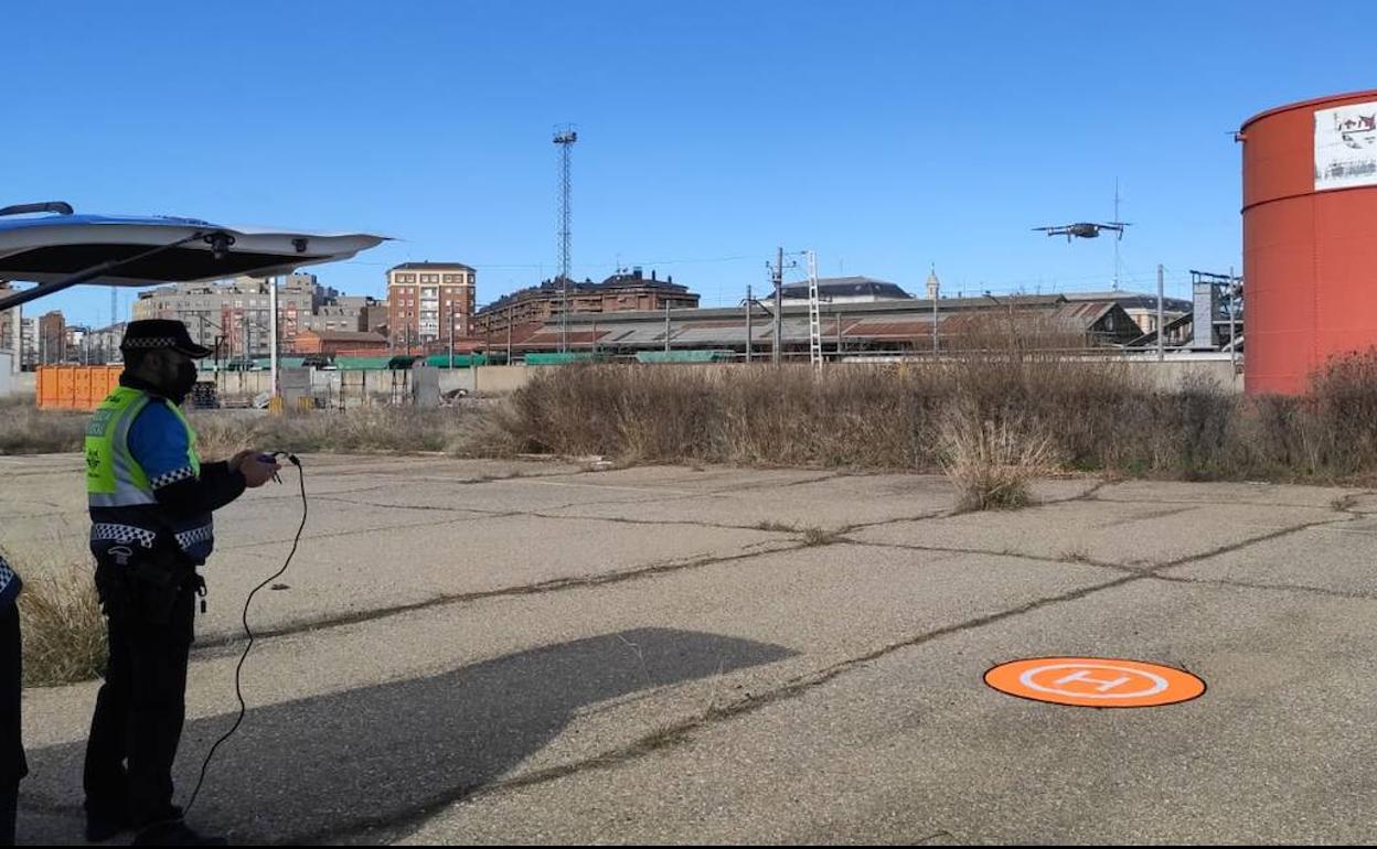 Un agente de la Unidad de Drones vuela el aparato junto a la zona de los depósitos de Renfe. 