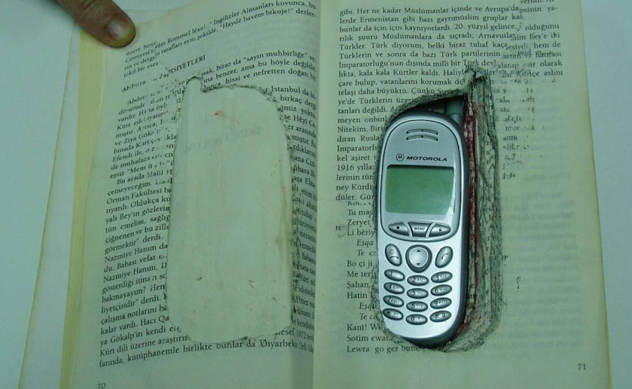 Teléfono móvil escondido en un libro. 