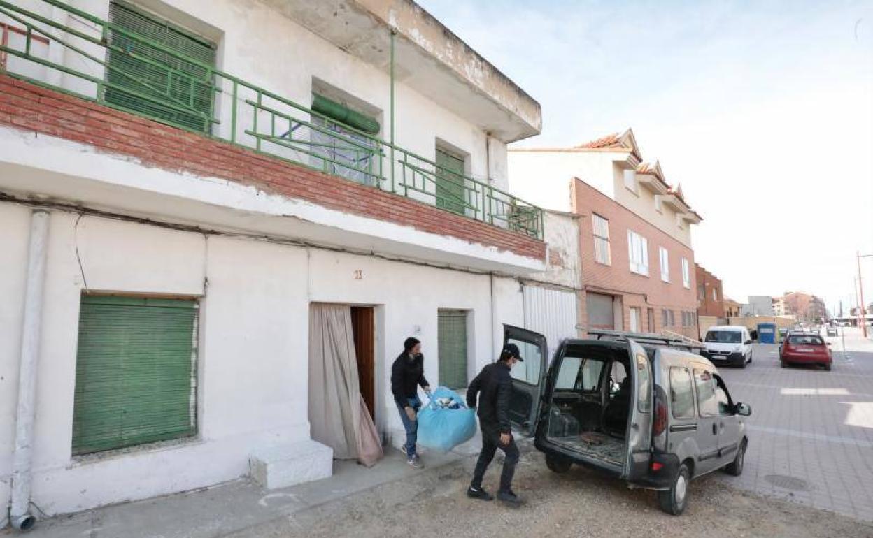 Dos hombres sacan sus enseres de la vivienda que habían ocupado en La Cistérniga. 