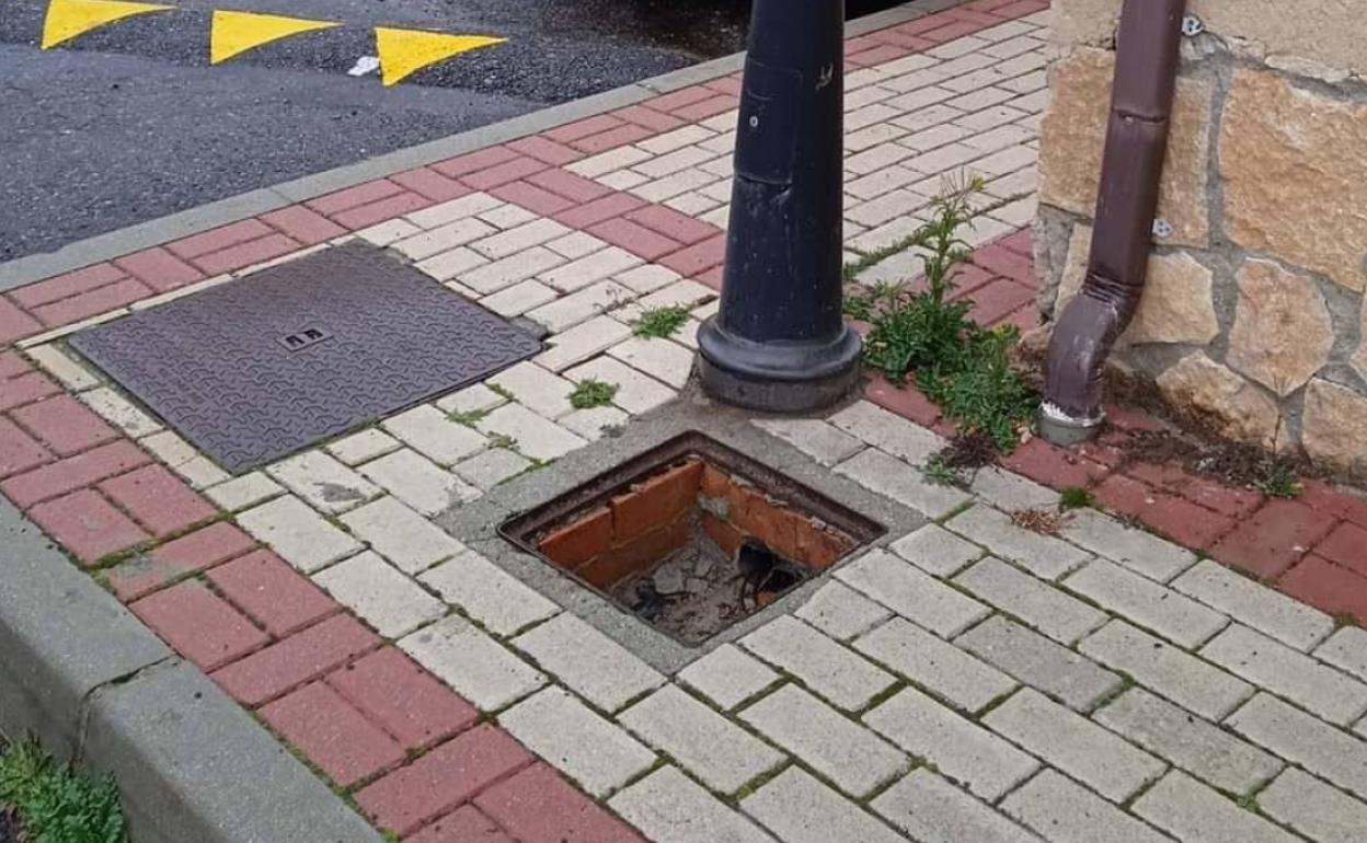 Hueco dejado en una calle de Torrecaballeros tras el robo de una tapadera del registro de la luz. 