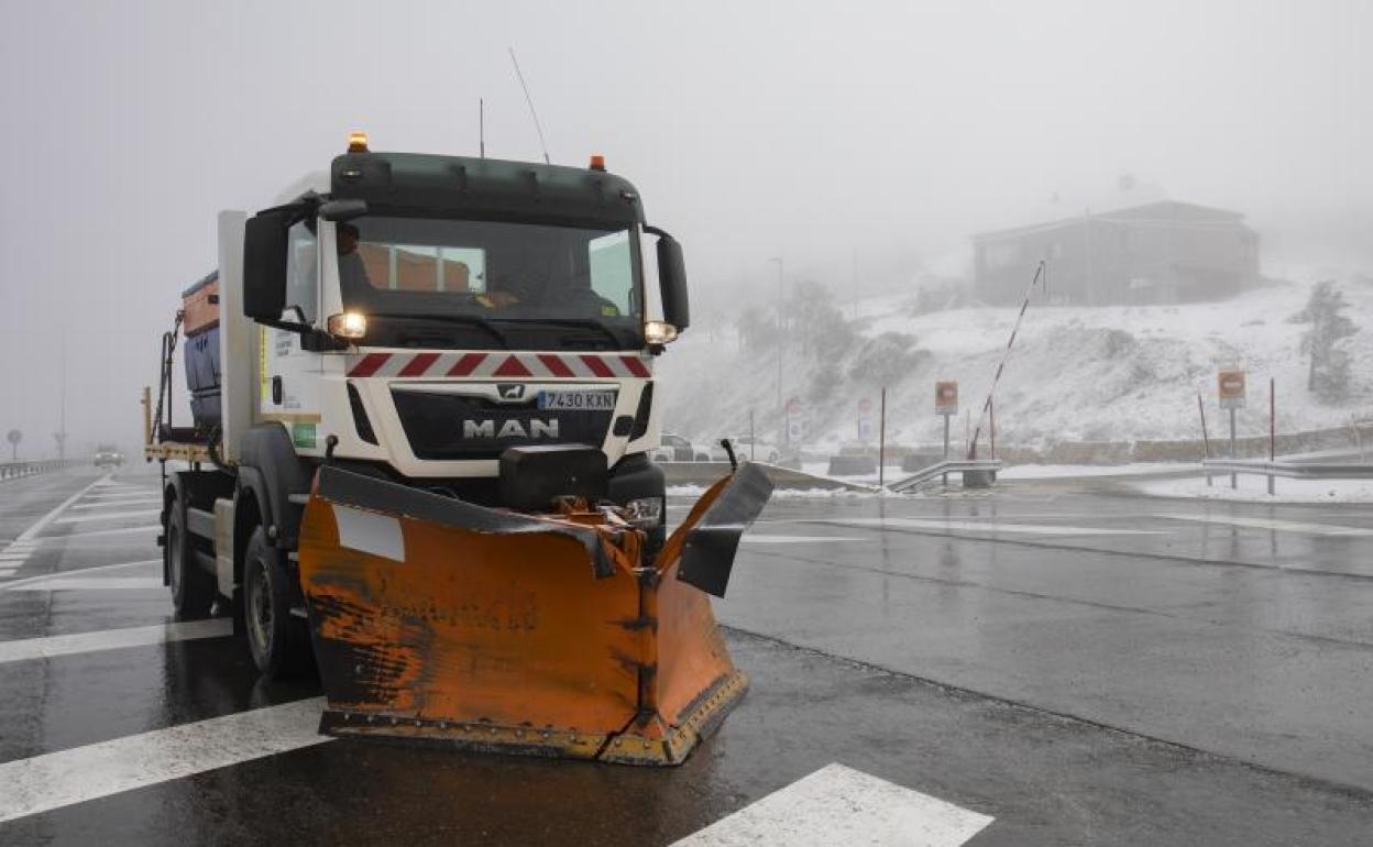Una máquina quitanieves pasa por el Puerto de Navacerrada para despejar la nieve de las carretera. 
