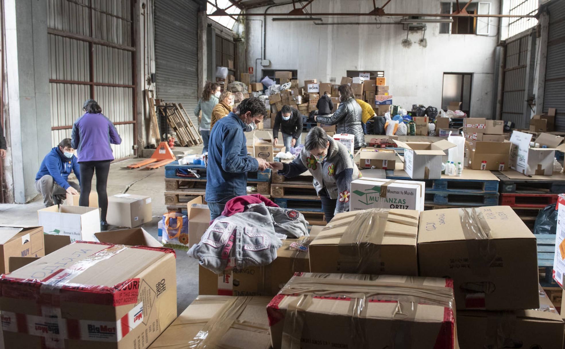 Voluntarios recogen y organizan, este jueves, los paquetes con ayuda para la población ucraniana apilados en la nave de los viejos bomberos de Segovia. 
