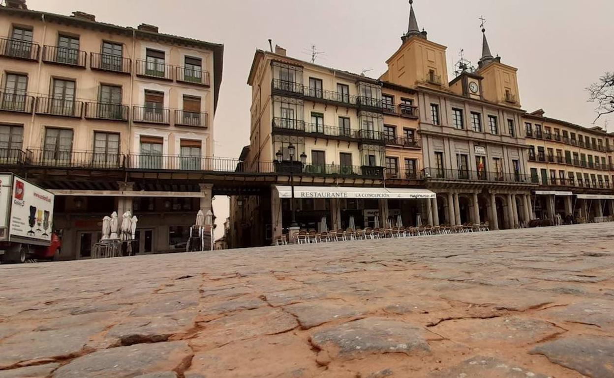 El suelo adoquinado de la Plaza Mayor cubierto del polvo anaranjado de la calima que se ha instalado en Segovia. 