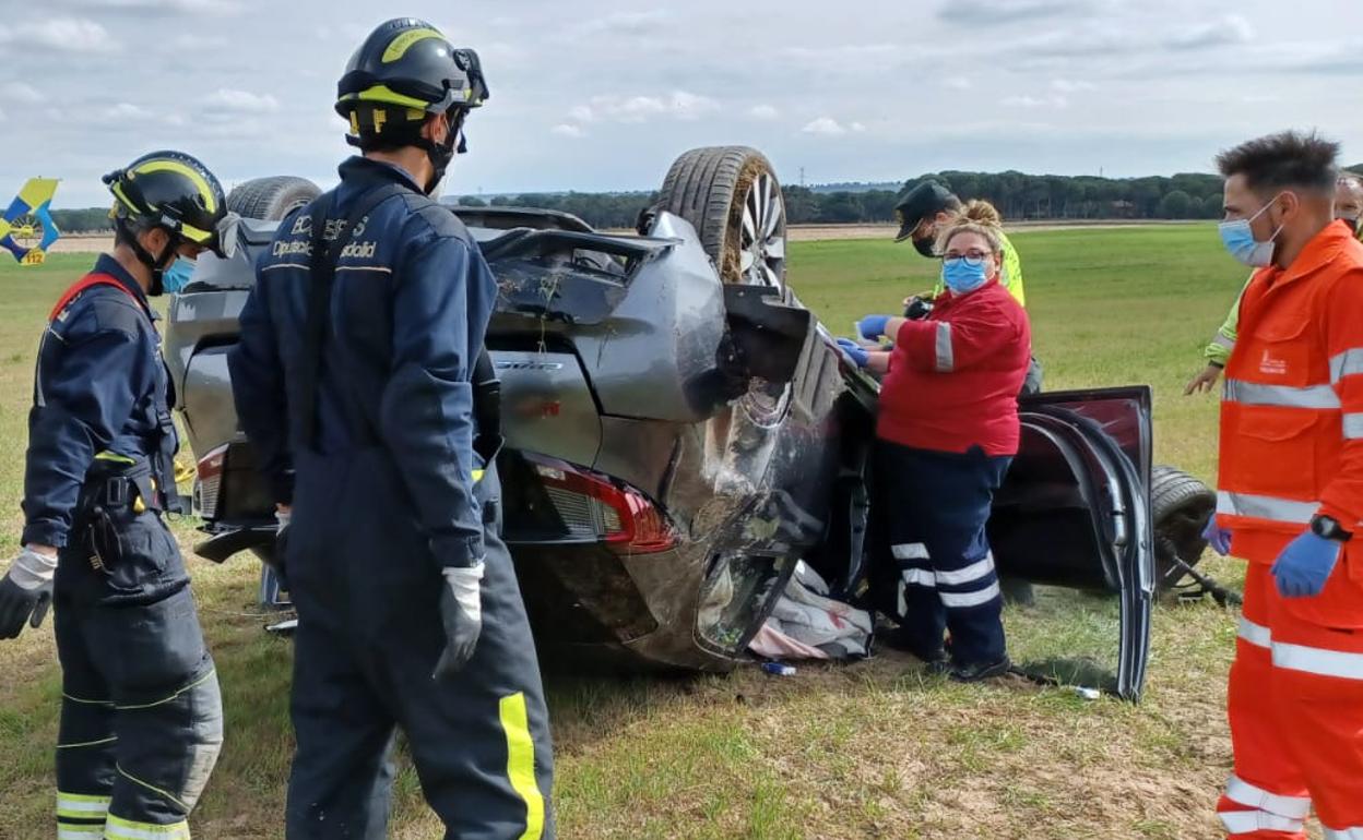 Bomberos y miembros del equipo médico junto al vehículo accidentado. 