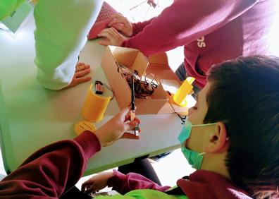 Imagen secundaria 1 - Arriba, tres de los alumnos que han participado en el proyecto con los dos satélites en la mano. Sobre estas líneas, varias fases del montaje antes del lanzamiento. 