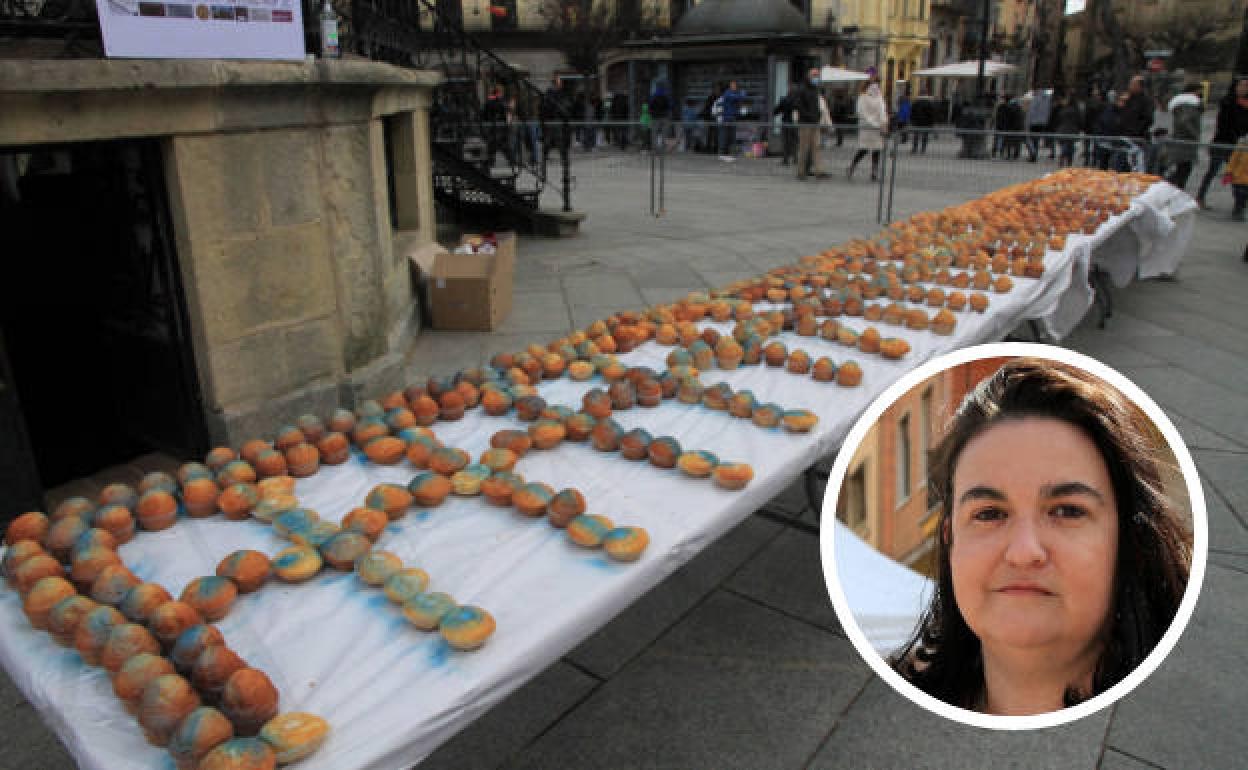 Susana Guri, presidenta de Autismo Segovia, en el círculo, junto a las 500 magdalenas que formaron el Acueducto antes de la degustación. 