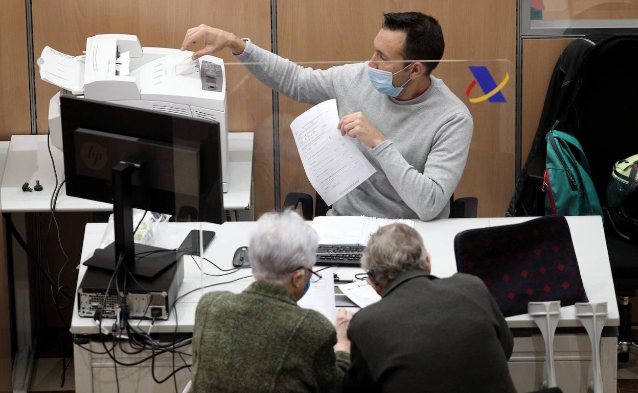 Una pareja de contribuyentes realiza su declaración de la Renta de forma presencial. 