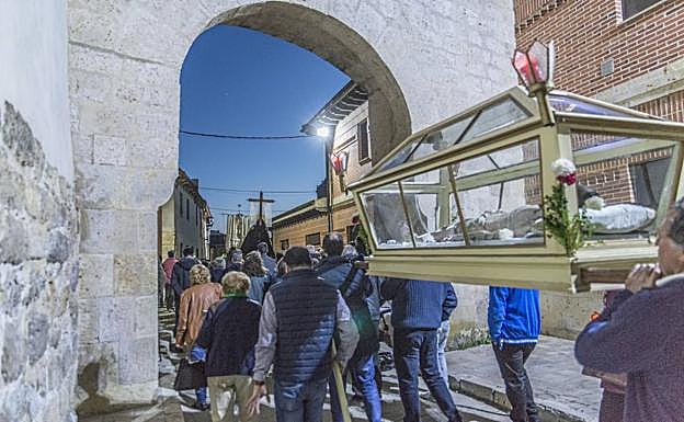La urna con el Cristo Yacente, a su paso por el arco. 