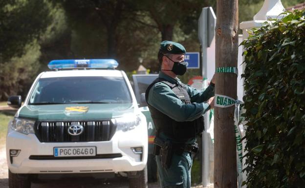 Un guardia precinta el acceso a la vivienda de los padres de Óscar, que está siendo registrada. 