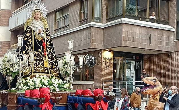 El hombre disfrazado de Tyrannosaurus rex, a la derecha de la imagen, observa a Nuestra Señora de los Dolores. 