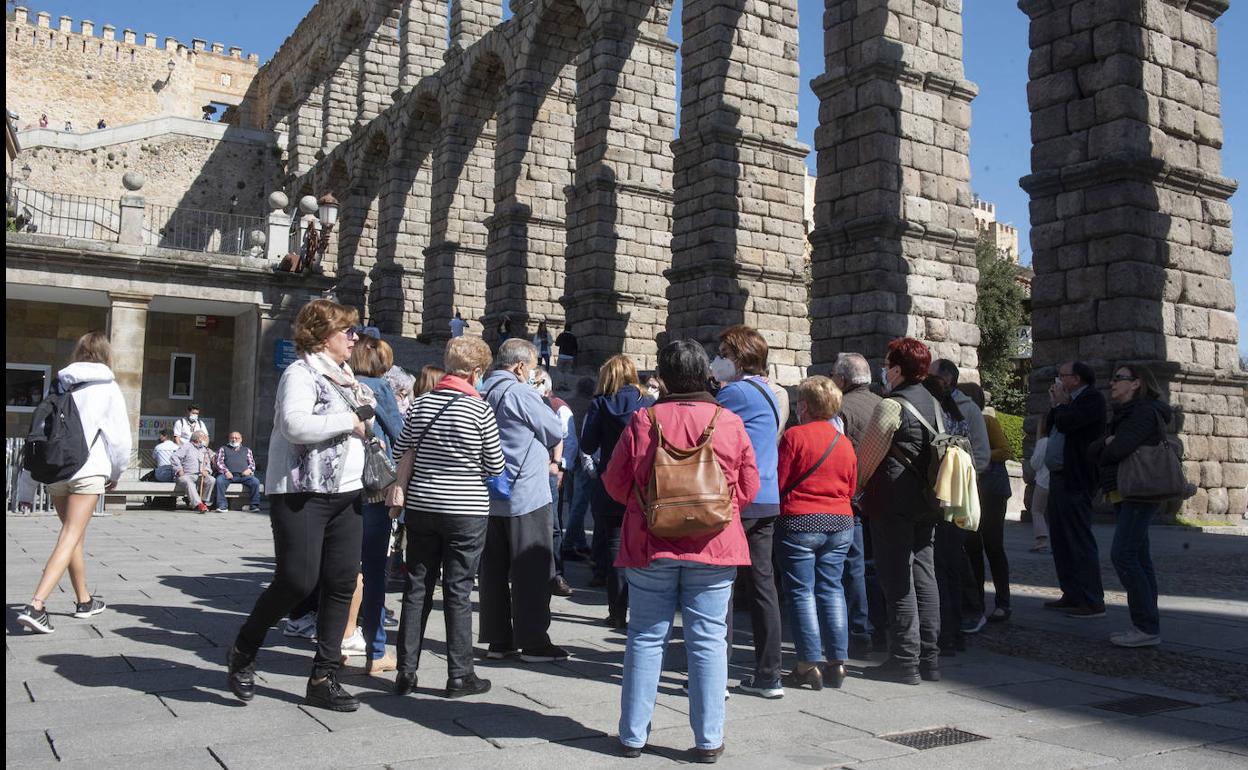 Personas en una visita guiada, junto al Acueducto.
