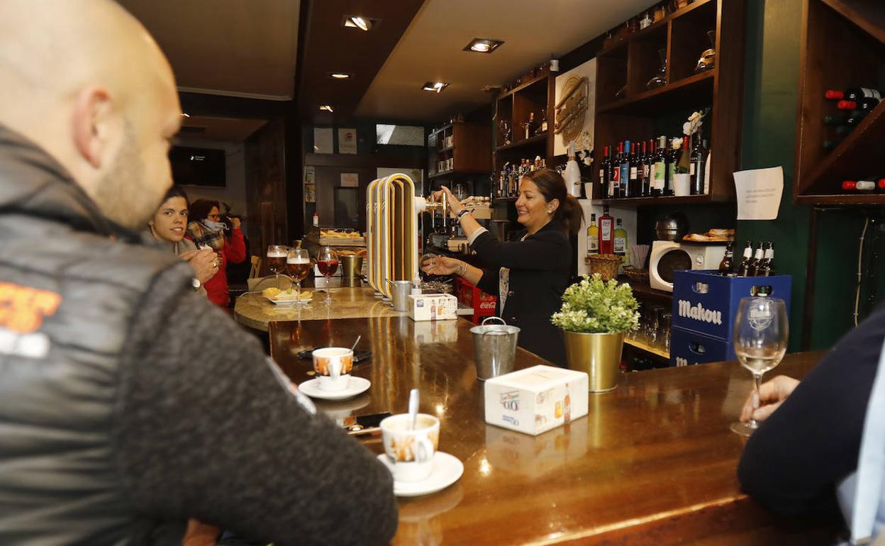 Una camarera atiende a los clientes sin mascarilla en un bar de Palencia, este miércoles.