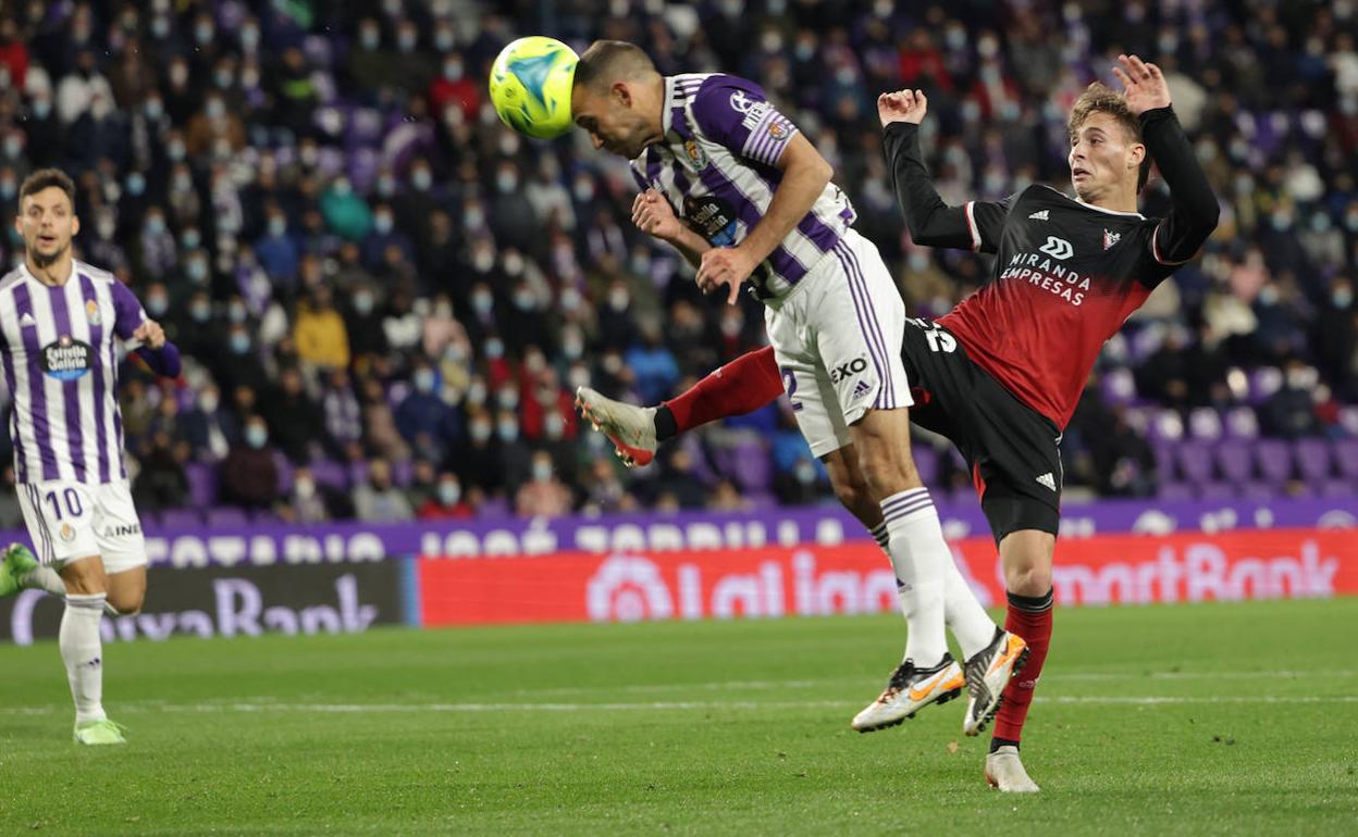 Nacho, del Real Valladolid, cabecea presionado por un rival del Mirandés en la primera vuelta. 