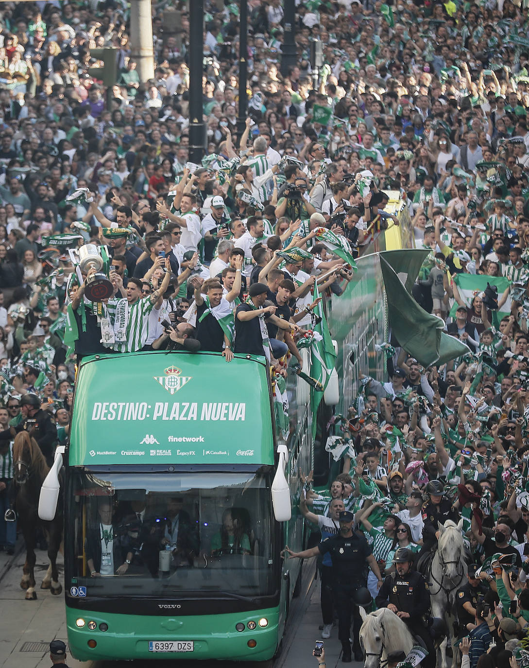 Una enorme multitud sigue al autocar con los jugadores del Betis durante su recorrido por la Avenida de la Constitución con destino al ayuntamiento de Sevilla, para celebrar su título de Copa del Rey.