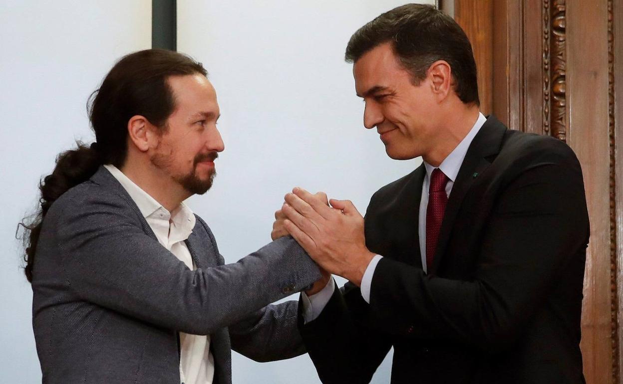 Pedro Sánchez y Pablo Iglesias, después de firmar el acuerdo programático que dio origen al Gobierno de coalición, en diciembre de 2019.