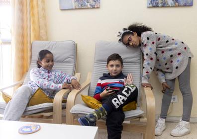 Imagen secundaria 1 - Arriba, las dos familias en el sofá de la casa de Adalberto. A la izquierda, Arseniy, junto a sus hermanas de acogida 