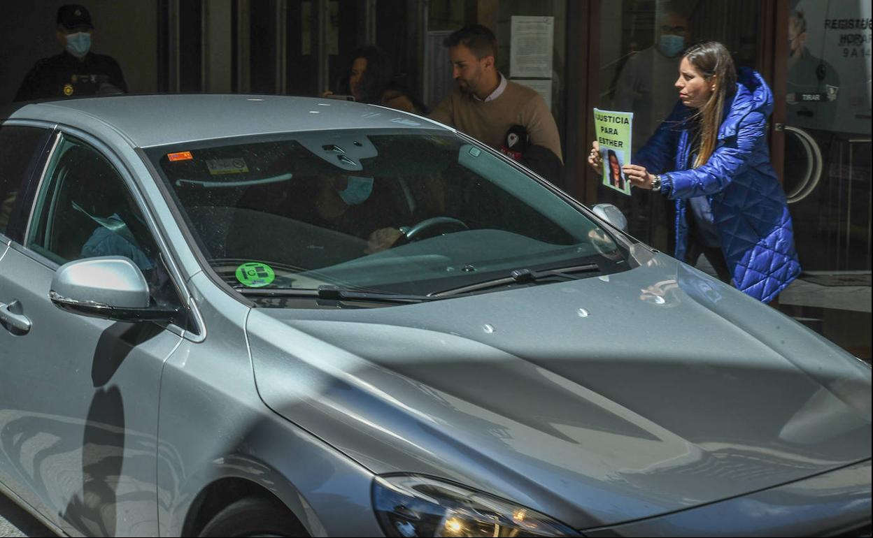 Una vecina de Traspinedo muestra un cartel a la salida de Óscar S. de los juzgados de Valladolid el pasado lunes. 
