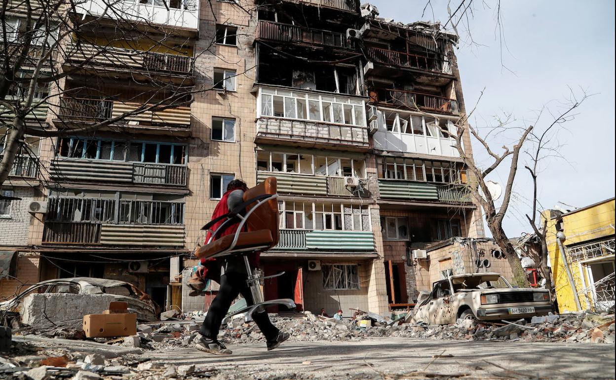 Un hombre pasa delante de un edificio destruido por los bombardeos de Rusia en la ciudad de Mariúpol.