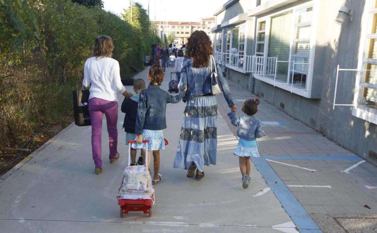 Madres llevan a sus hijos al colegio.