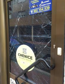 Imagen secundaria 2 - Arriba, puerta de acceso a la peluquería desencajada de la calle Unión. A la izquierda, coches patrullas en la calle Unión en la noche del domingo al lunes. A la derecha, puerta resquebrajada de la peluquería.