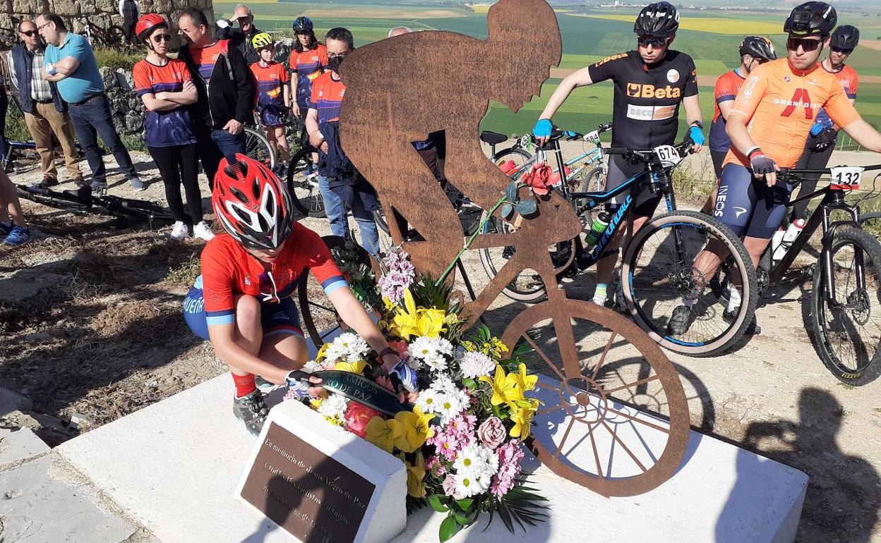 Ana, sobrina de Jesús Negro, coloca flores en el monumento memorial al ciclista..