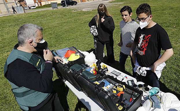 Un agente enseña material de criminalística a varios alumnos.