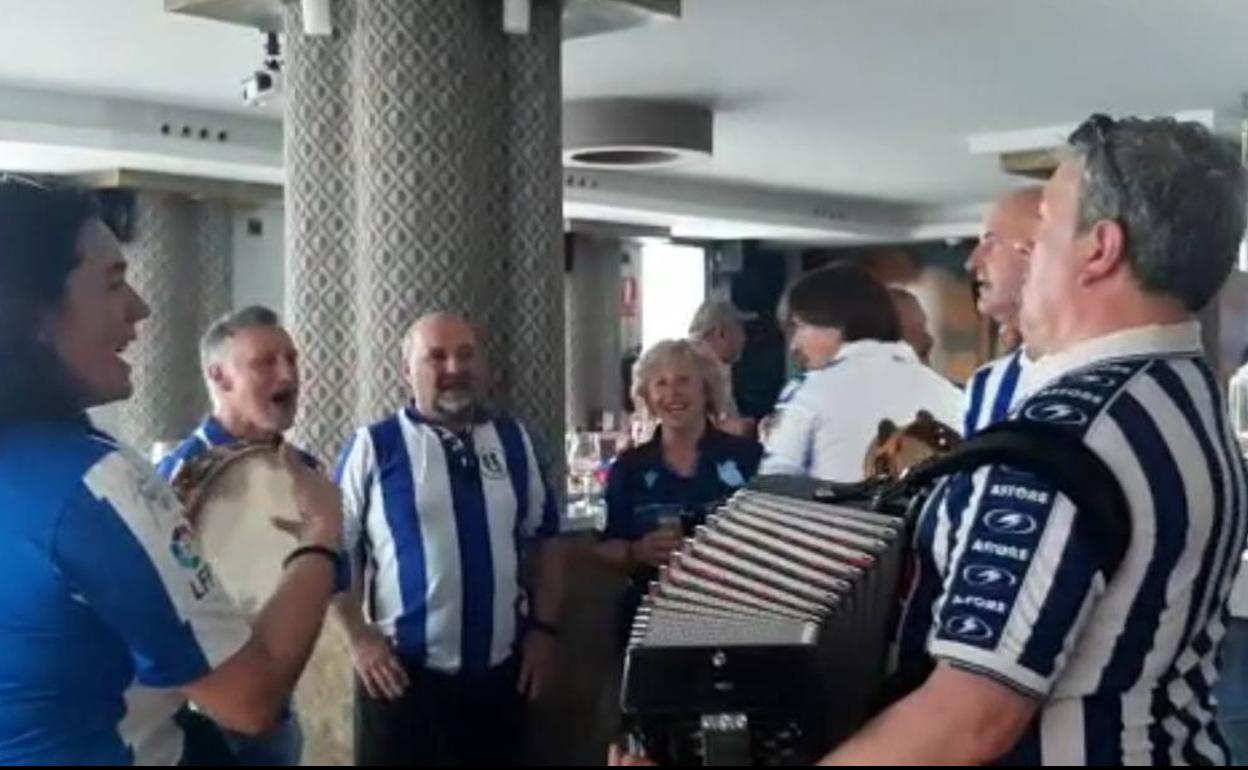 Aficionados de la Real Sociedad tocan el himno de su club este sábado en Becerril. 
