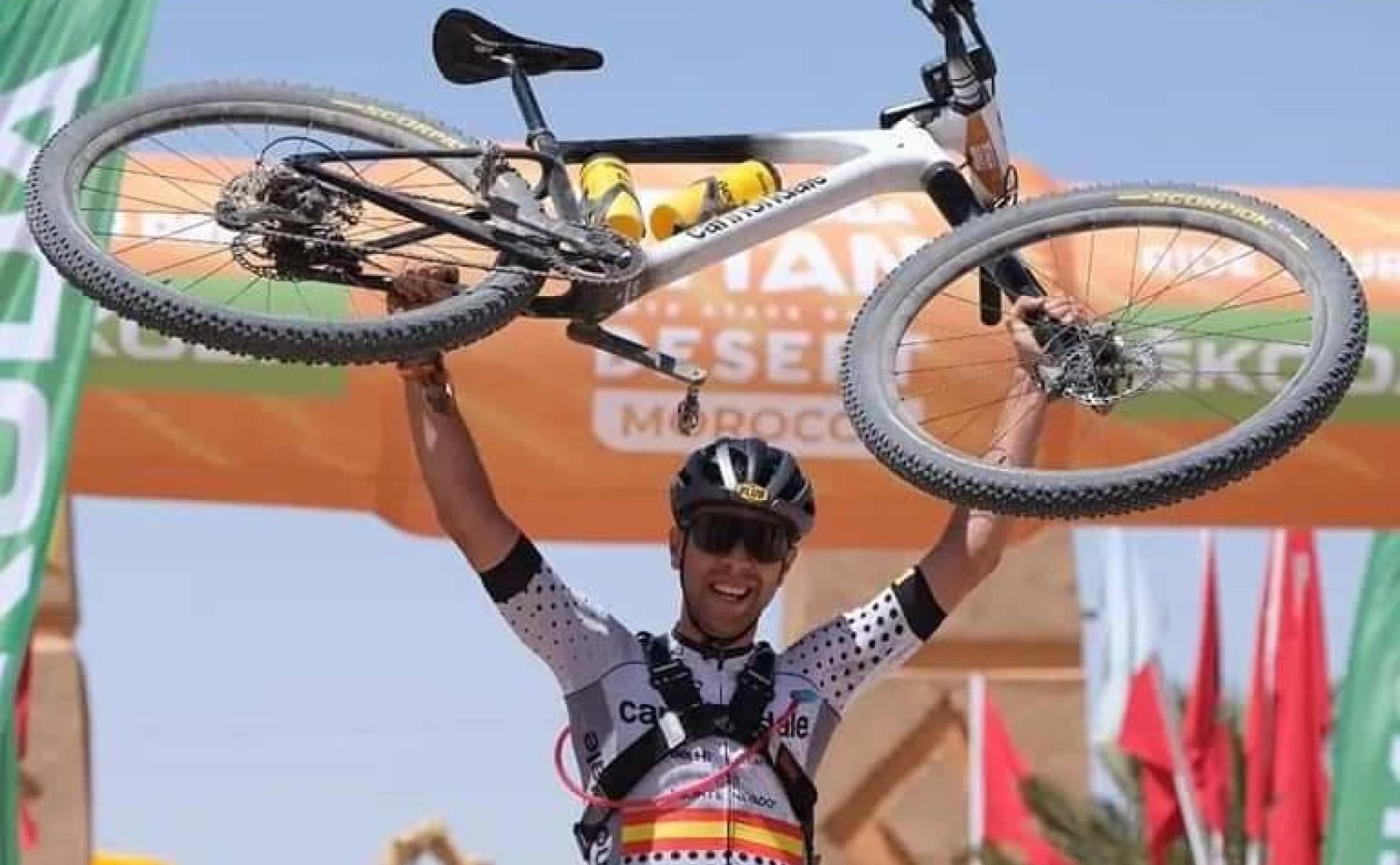 Fran Herrero levanta su bicicleta tras imponerse en una etapa.