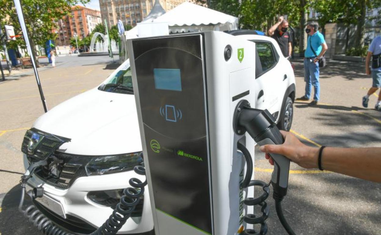 Un coche enchufado en un poste eléctrico. 